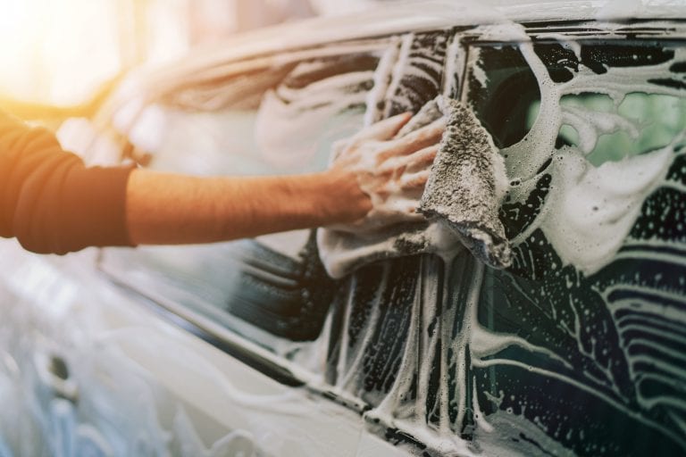 car being cleaned by soap and cloth