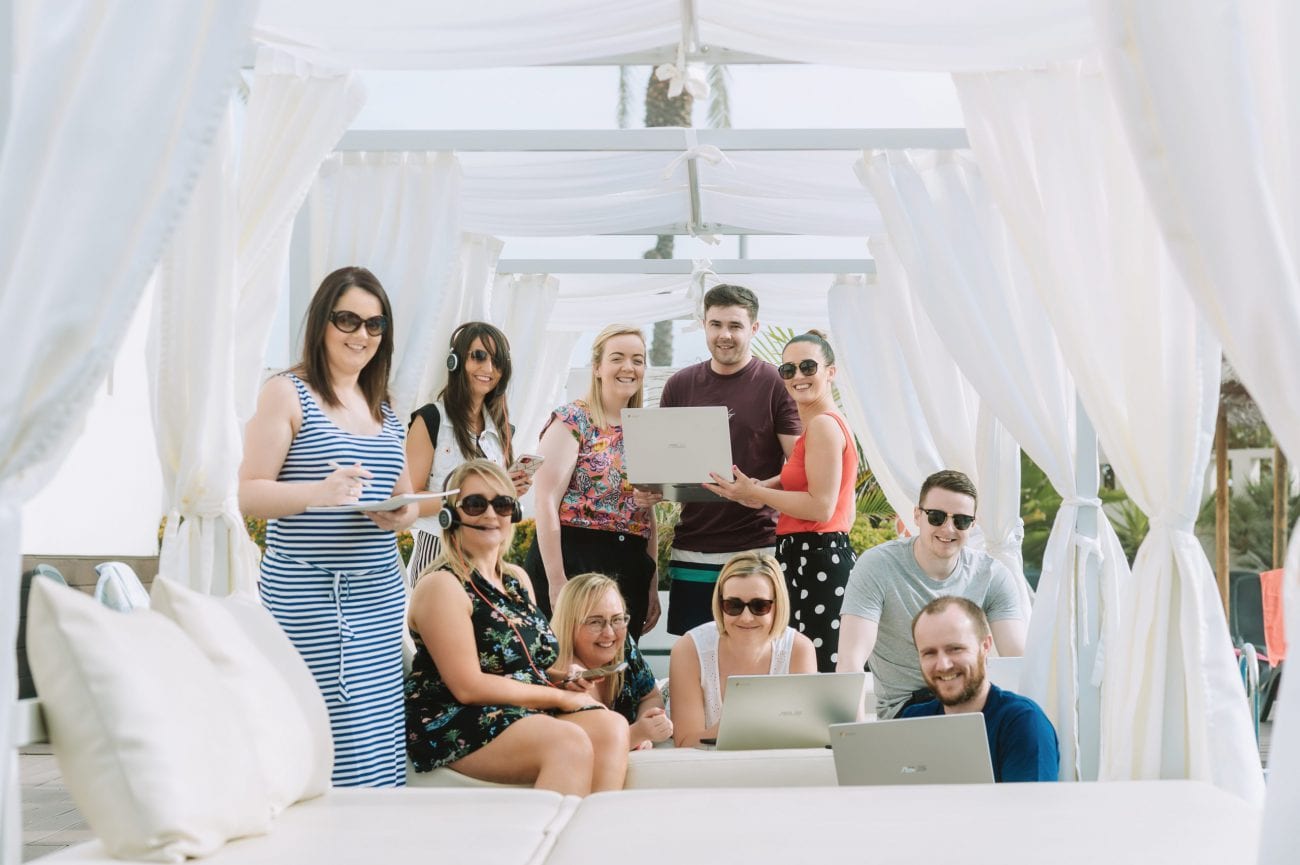 staff working from spain on laptops in the sun